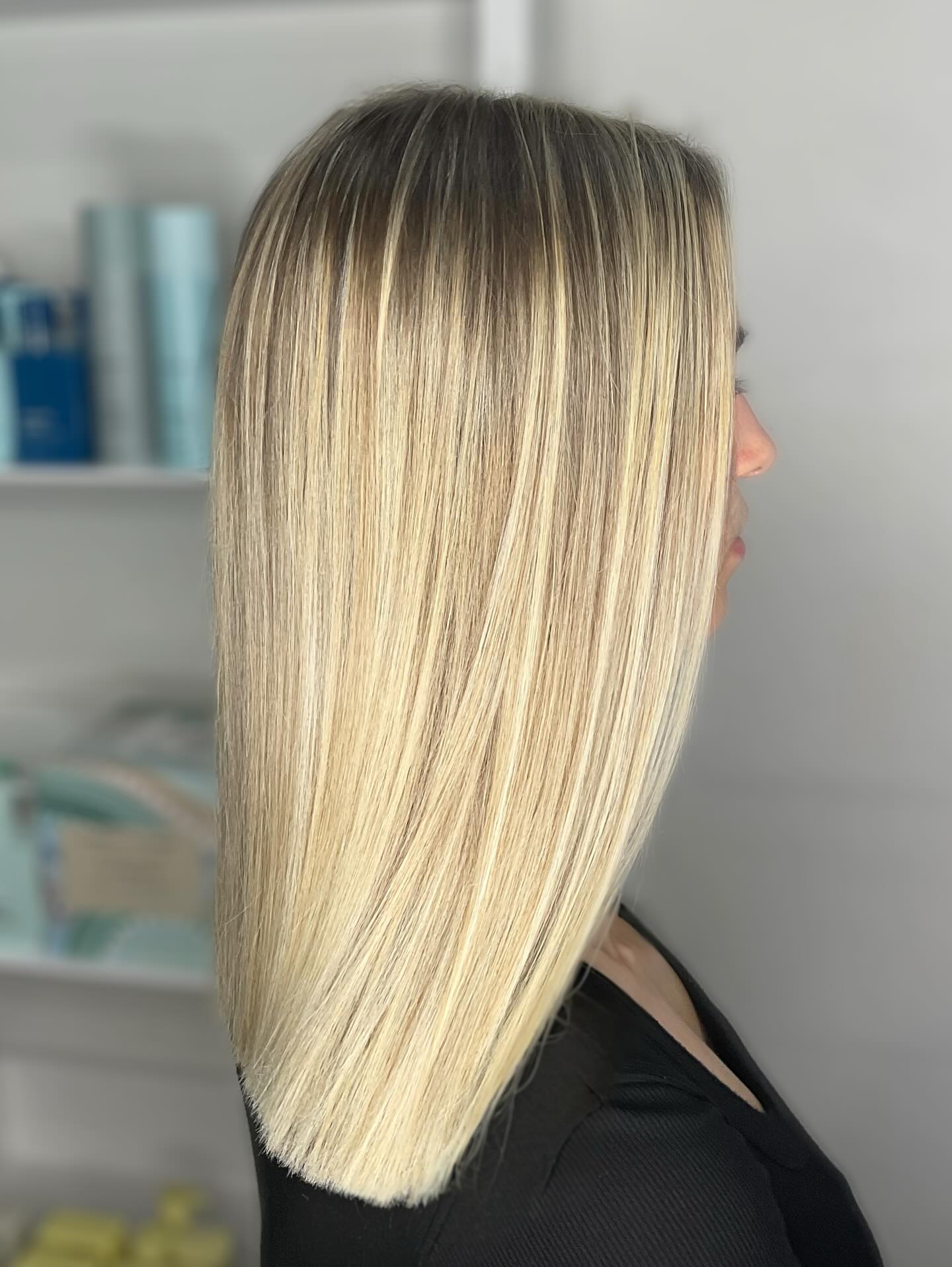 A sleek shoulder-length blonde cut with finely blended highlights, viewed from the side