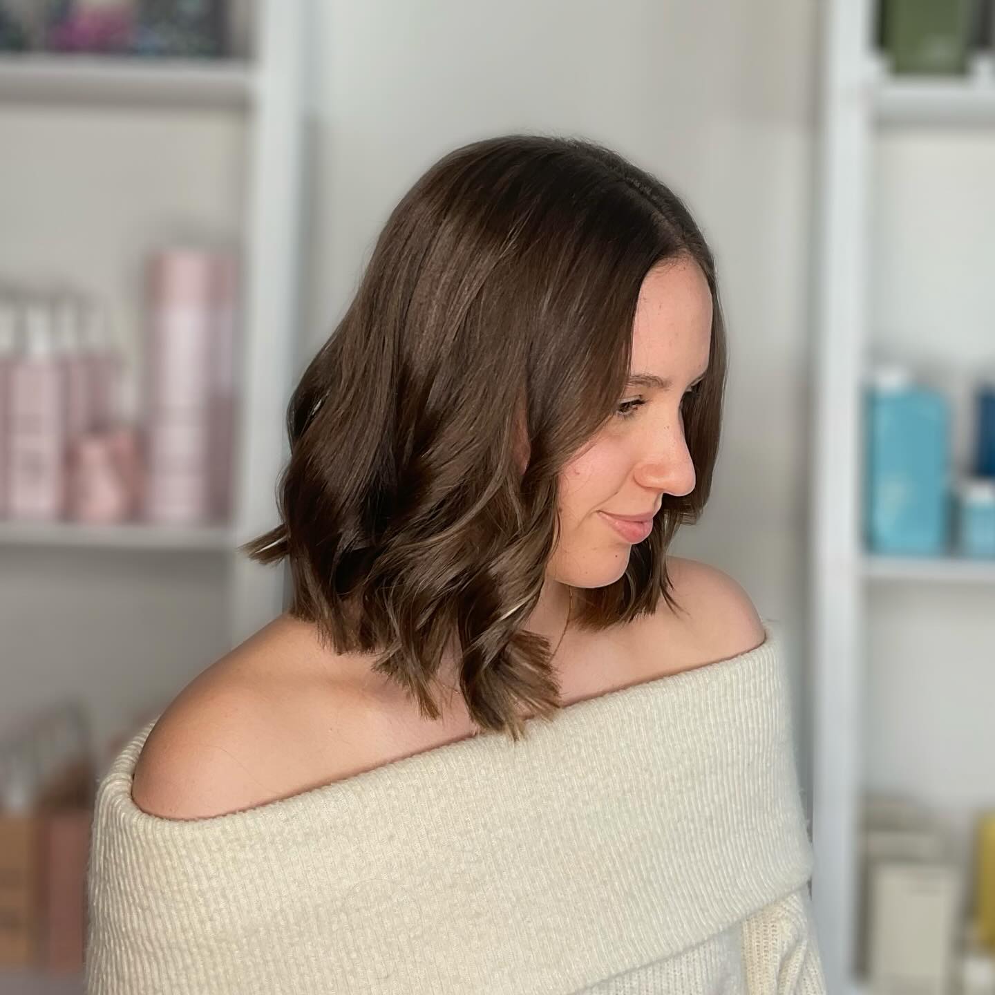 A shoulder-length brunette bob with soft waves, photographed in the salon